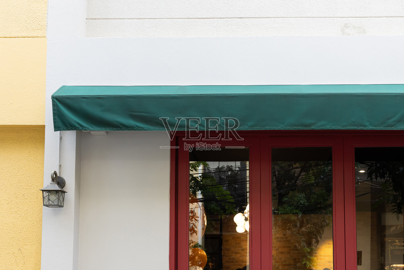 一个带有红色边框的窗户上方的绿色遮阳篷照片摄影图片