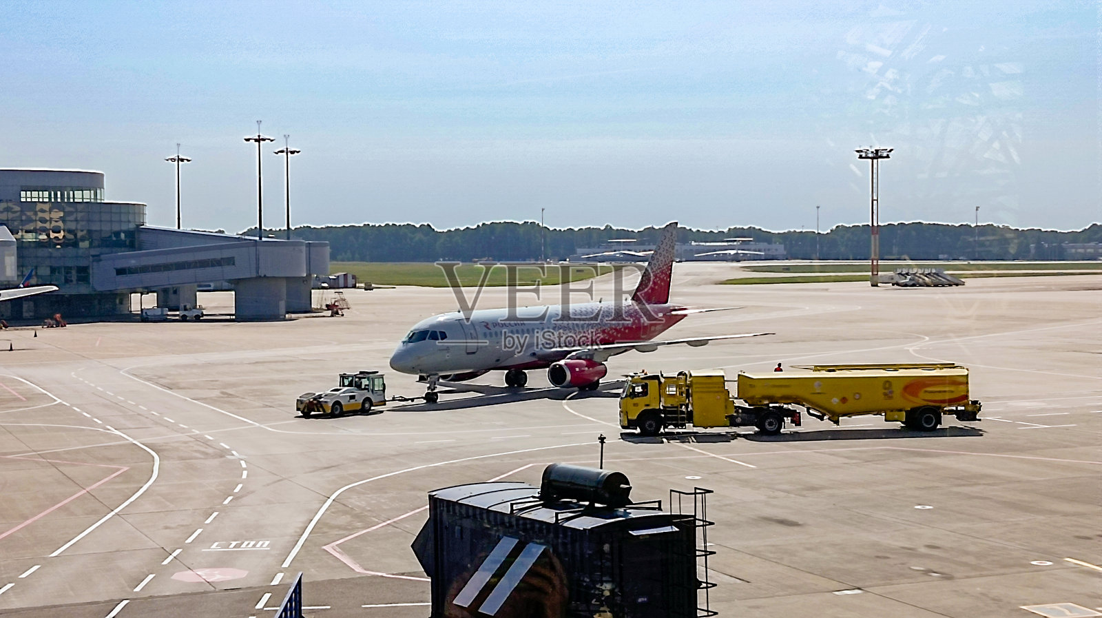飞机拖车在机场跑道上拖曳飞机。照片摄影图片