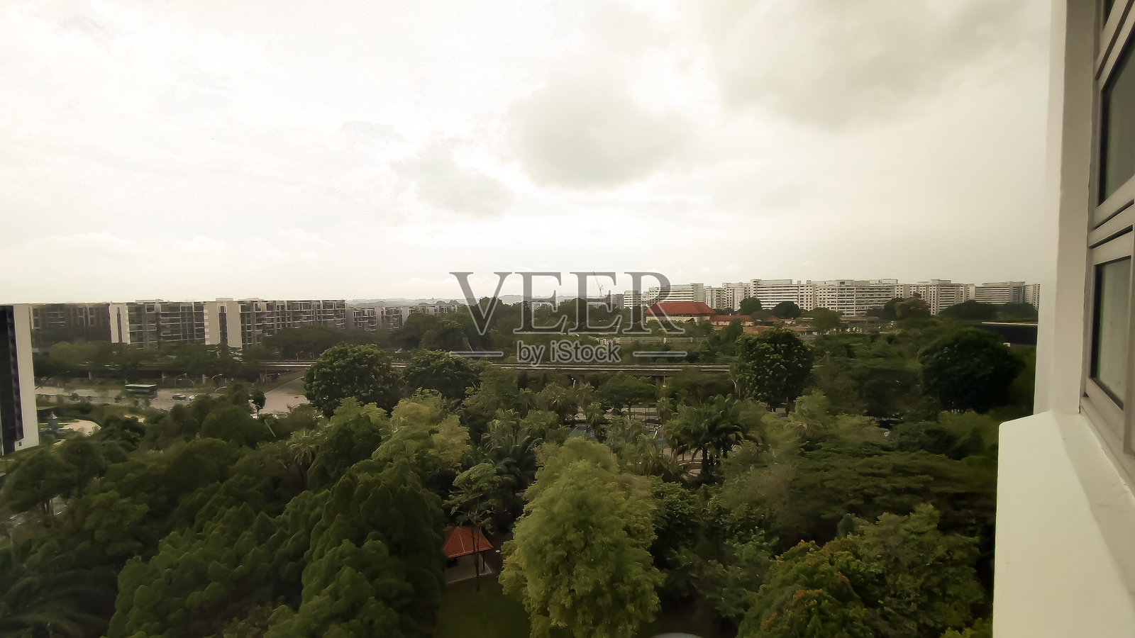 阴云密布的天空即将带来雨水，城市的绿意盎然。照片摄影图片