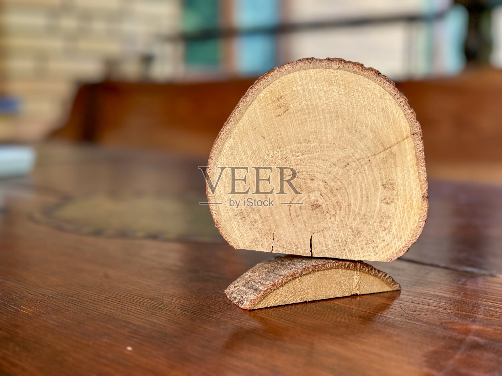 阳光明媚的白天，桌子上的自然木艺作品与郁郁葱葱的绿色背景相映成趣。照片摄影图片