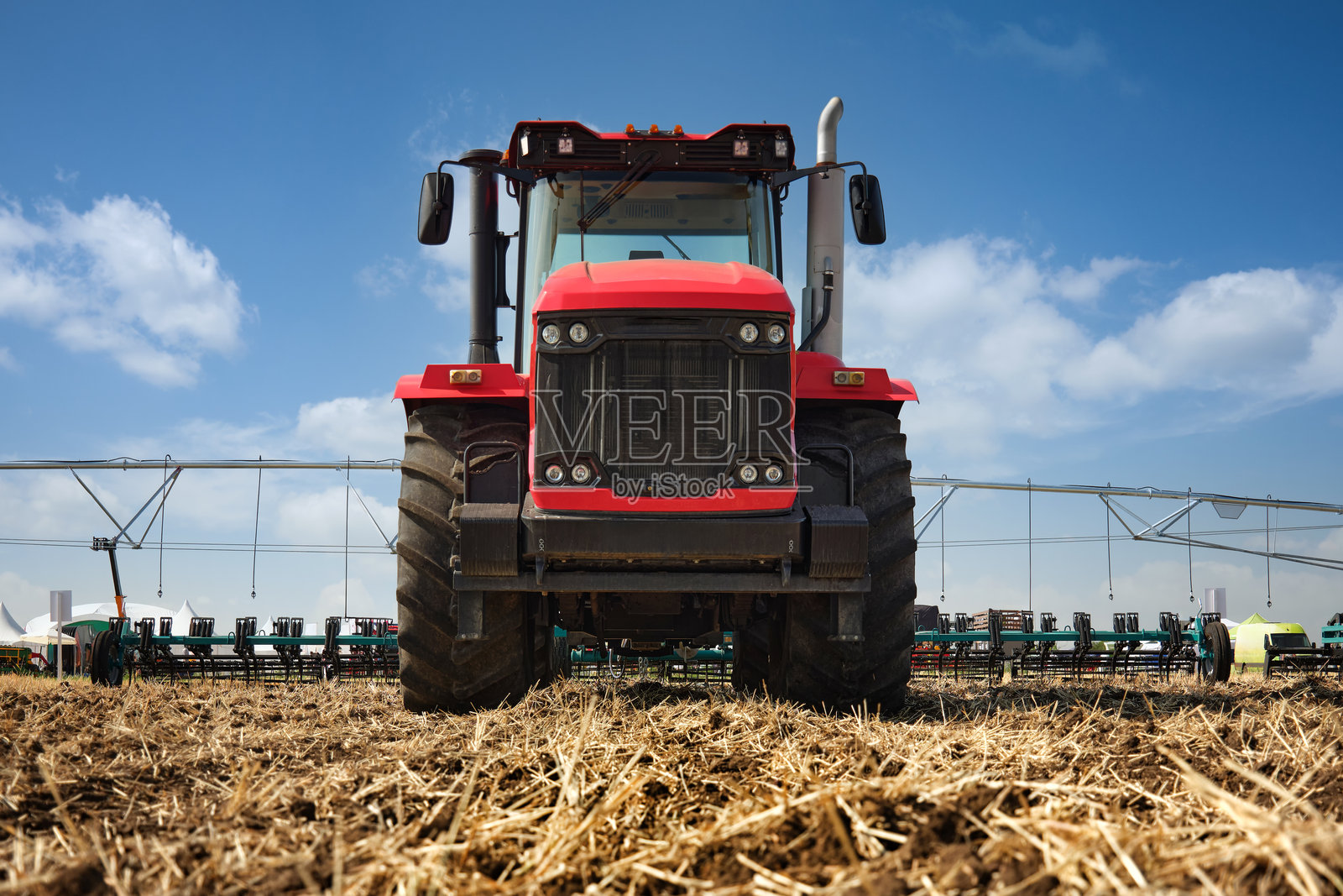 一台大型拖拉机在田地里耕作，开始收获后的耕作。照片摄影图片