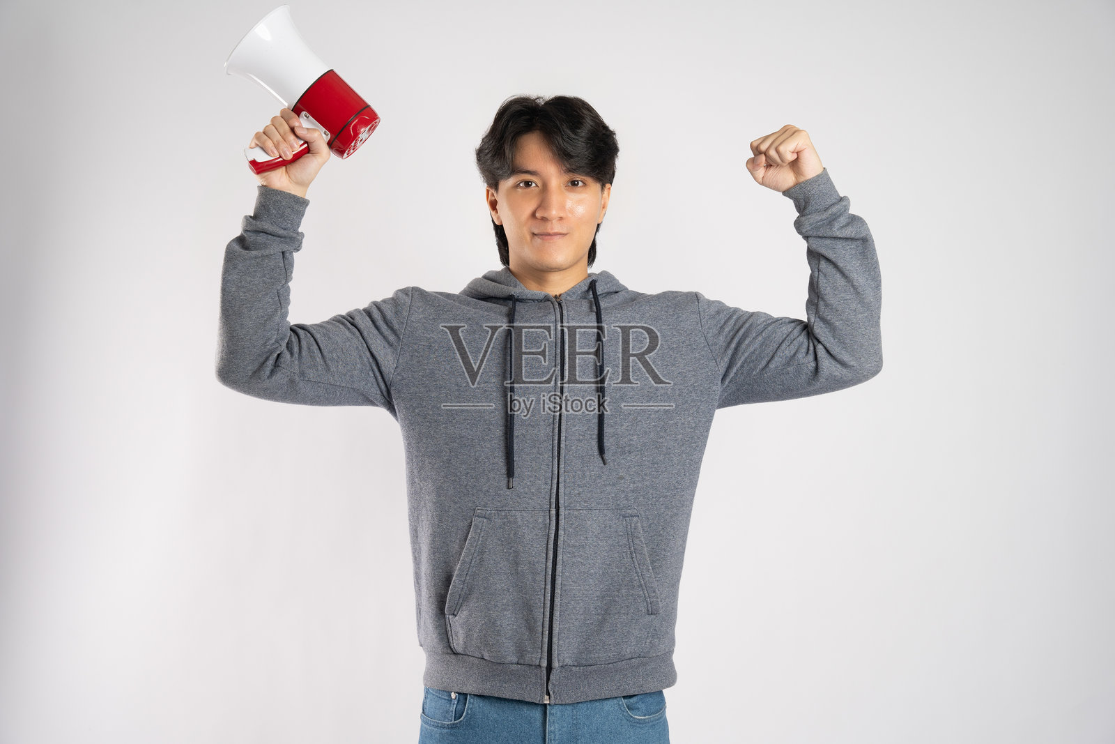 穿着连帽衫的亚洲男子在白色背景前摆姿势的肖像照片摄影图片