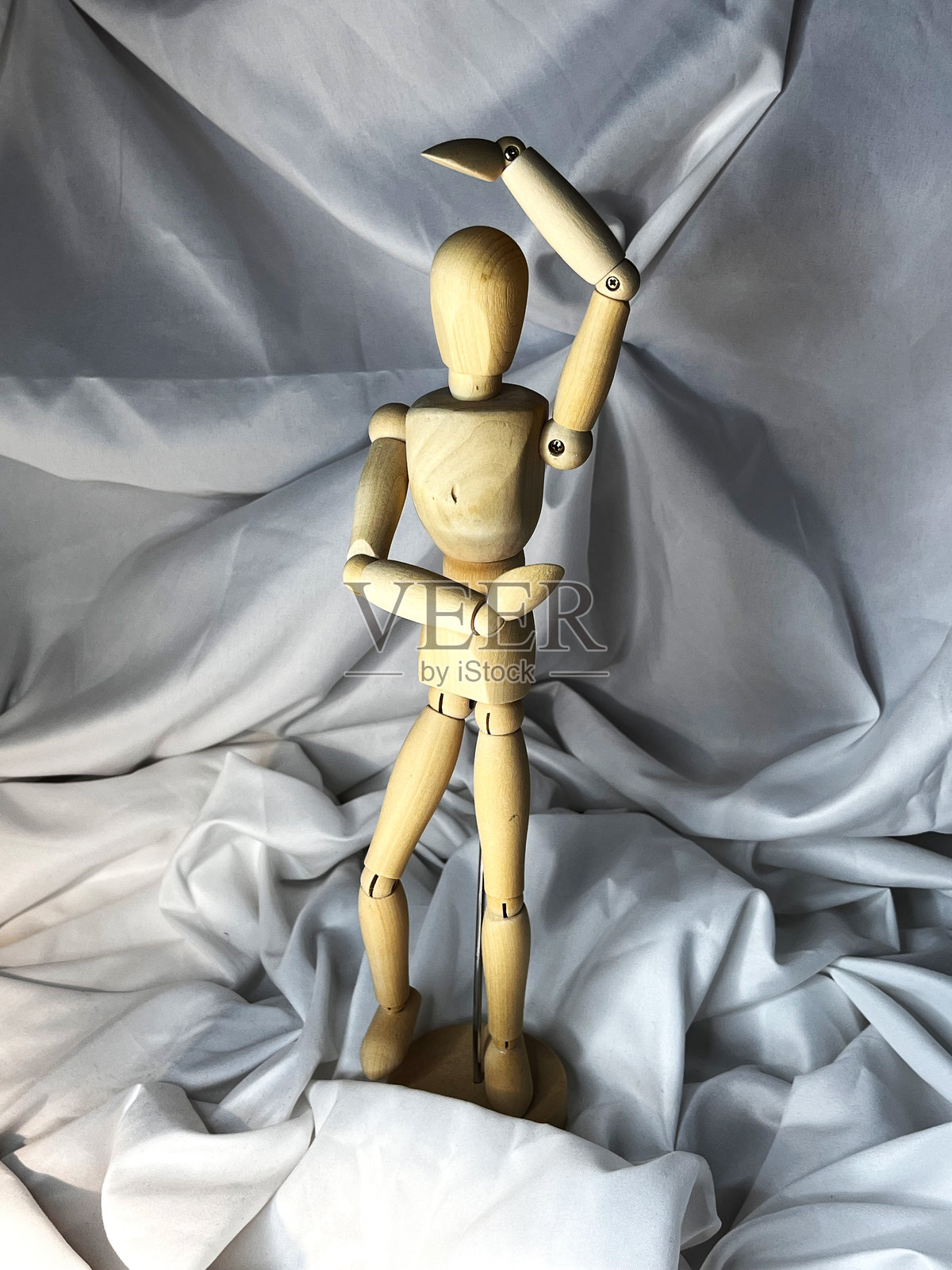 木制绘画模特人偶，帮助艺术家展示姿势，背景为白色纺织品照片摄影图片