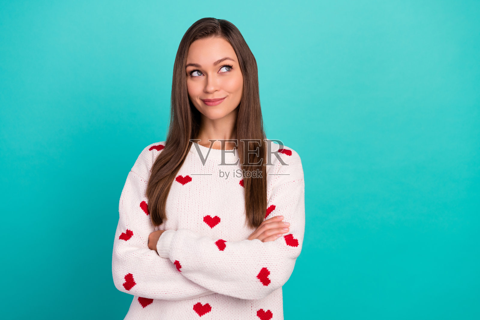若有所思的漂亮女士，双手交叉，对空白区域感兴趣照片摄影图片