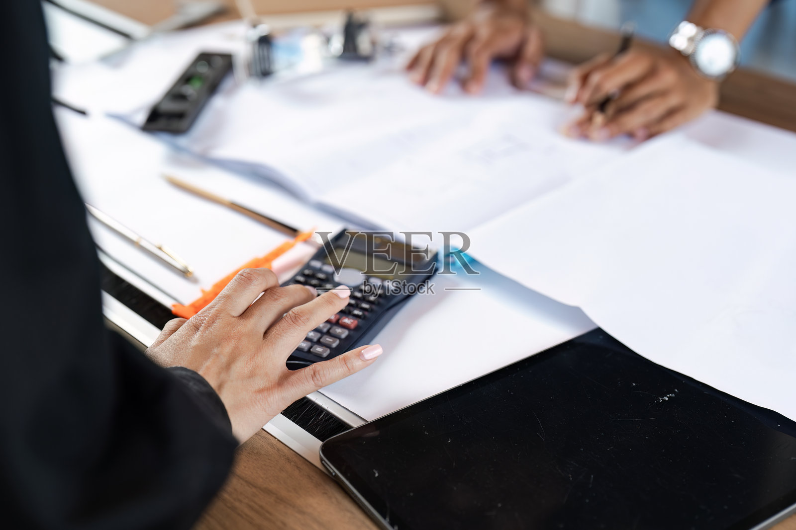 工程师在桌上使用计算器和技术工具进行蓝图和计算工作照片摄影图片