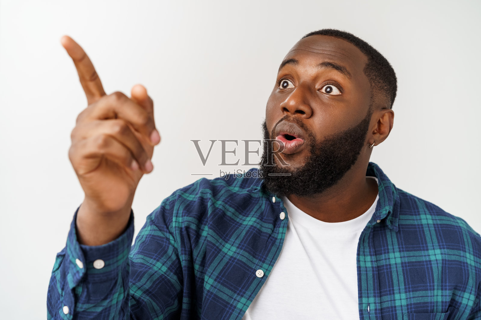 年轻男子在白色背景下指着前方照片摄影图片