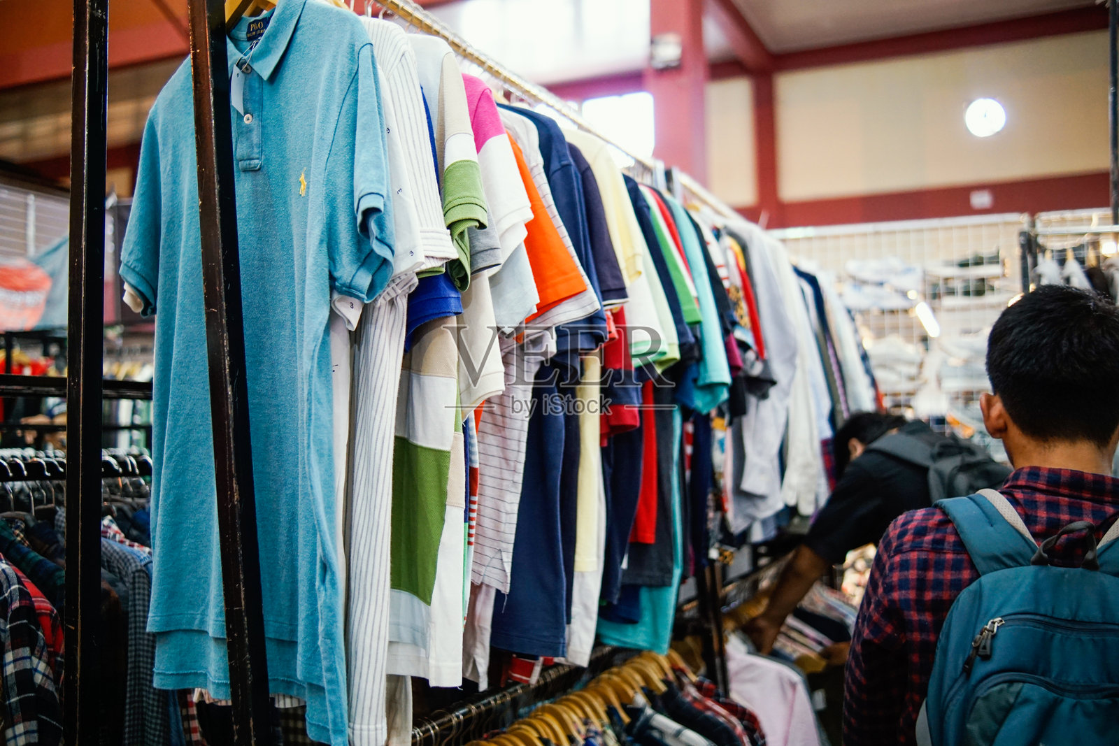 购物者在挑选二手衣物和鞋子。照片摄影图片