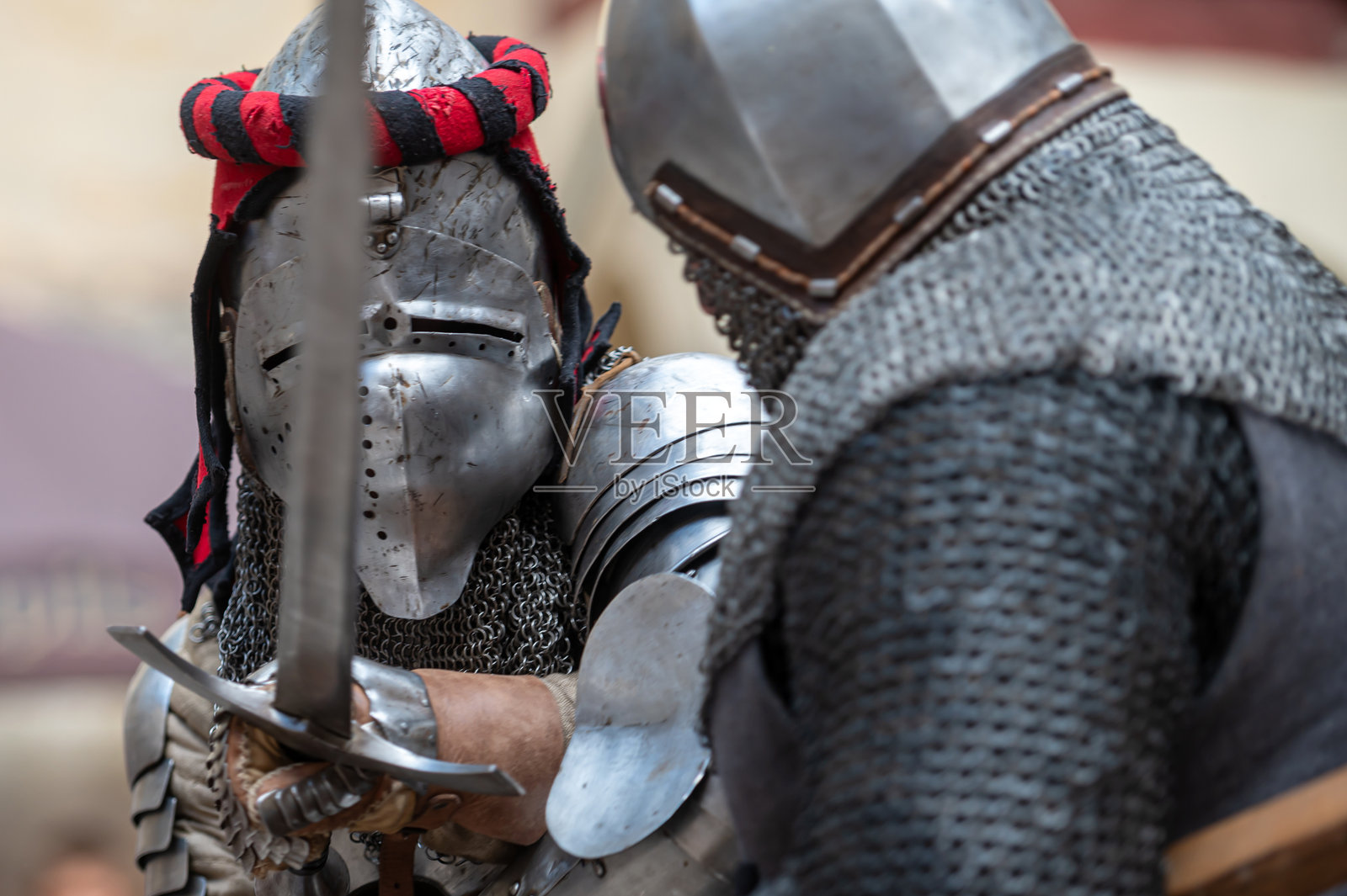 在中世纪历史重演活动中，身穿盔甲的骑士进行剑 duel照片摄影图片