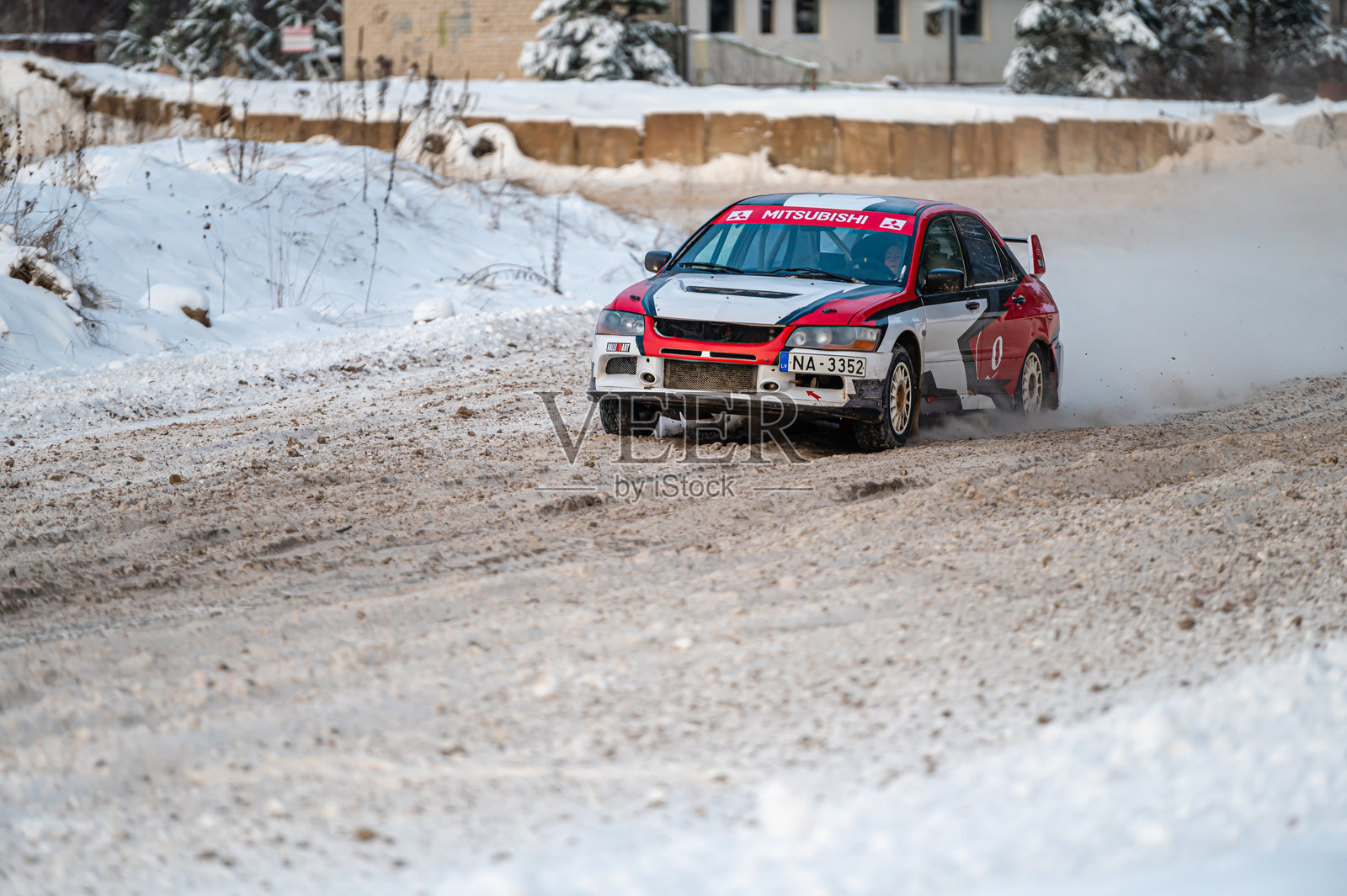 年轻人在冬季赛道上安全驾驶三菱蓝瑟Evo跑车照片摄影图片