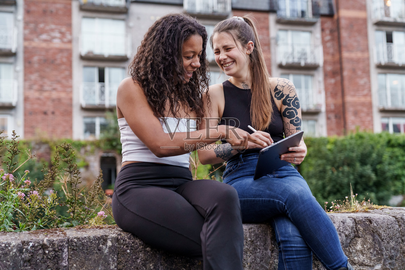 年轻女人们笑着使用平板电脑照片摄影图片