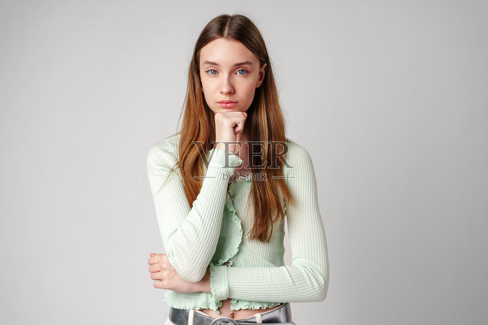 若有所思的棕色长发年轻女人，白色背景照片摄影图片