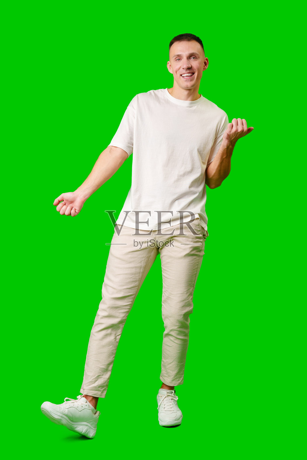 快乐的年轻男子在绿色背景下举起双臂庆祝照片摄影图片