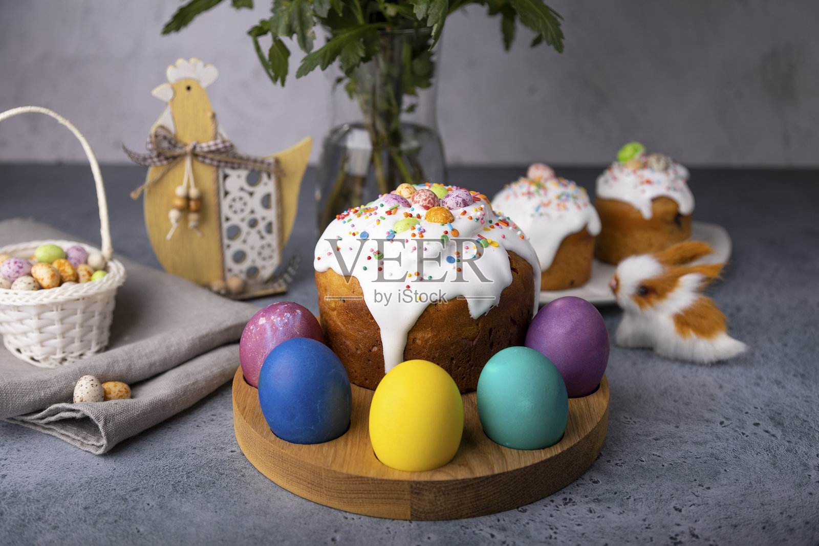 复活节的水果蛋糕，覆盖着白色糖霜，撒上五彩糖屑和染色的鸡蛋。传统的复活节烘焙食品。复活节庆祝活动。照片摄影图片