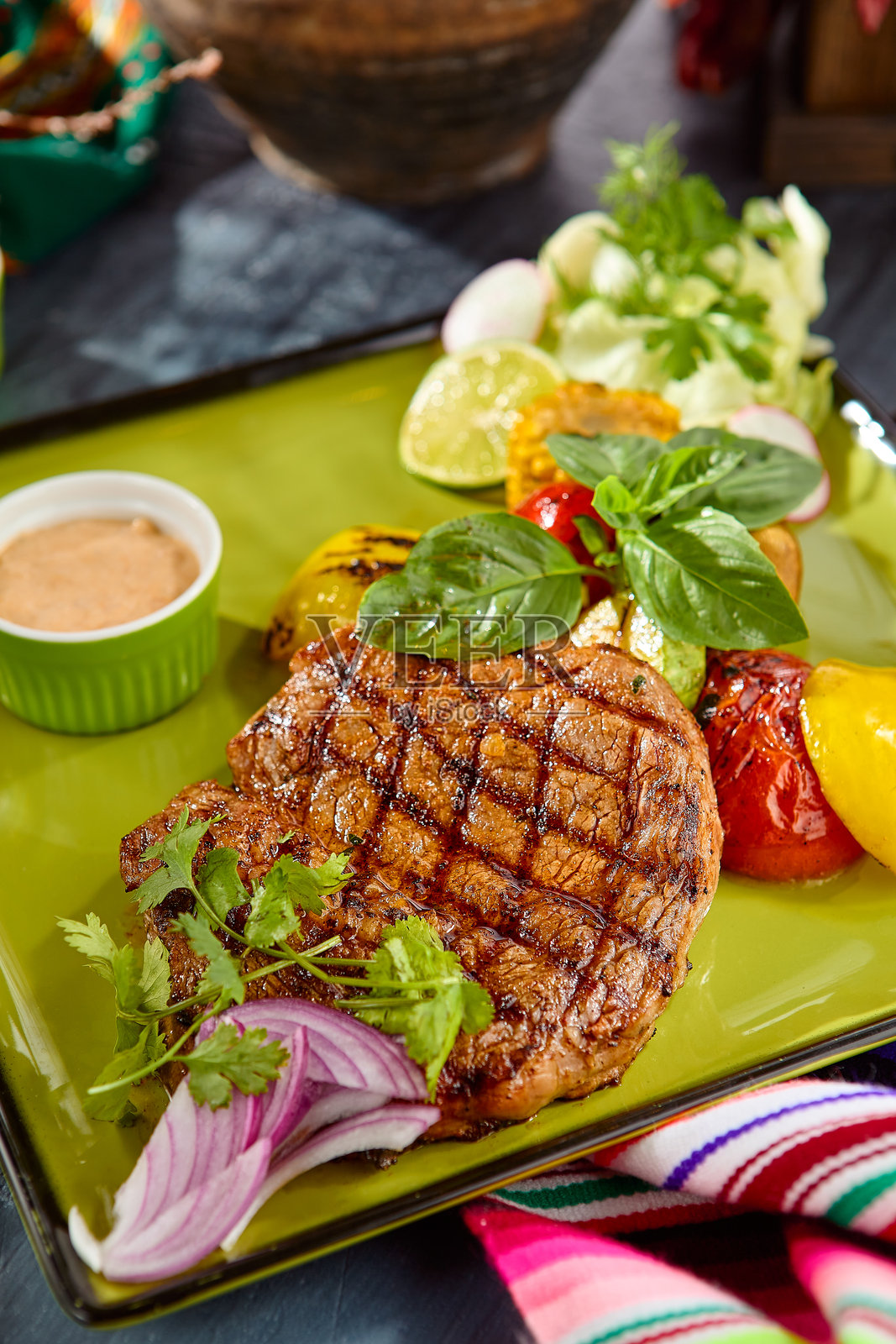 多汁的肋眼牛排配烤蔬菜，放在绿色盘子上照片摄影图片