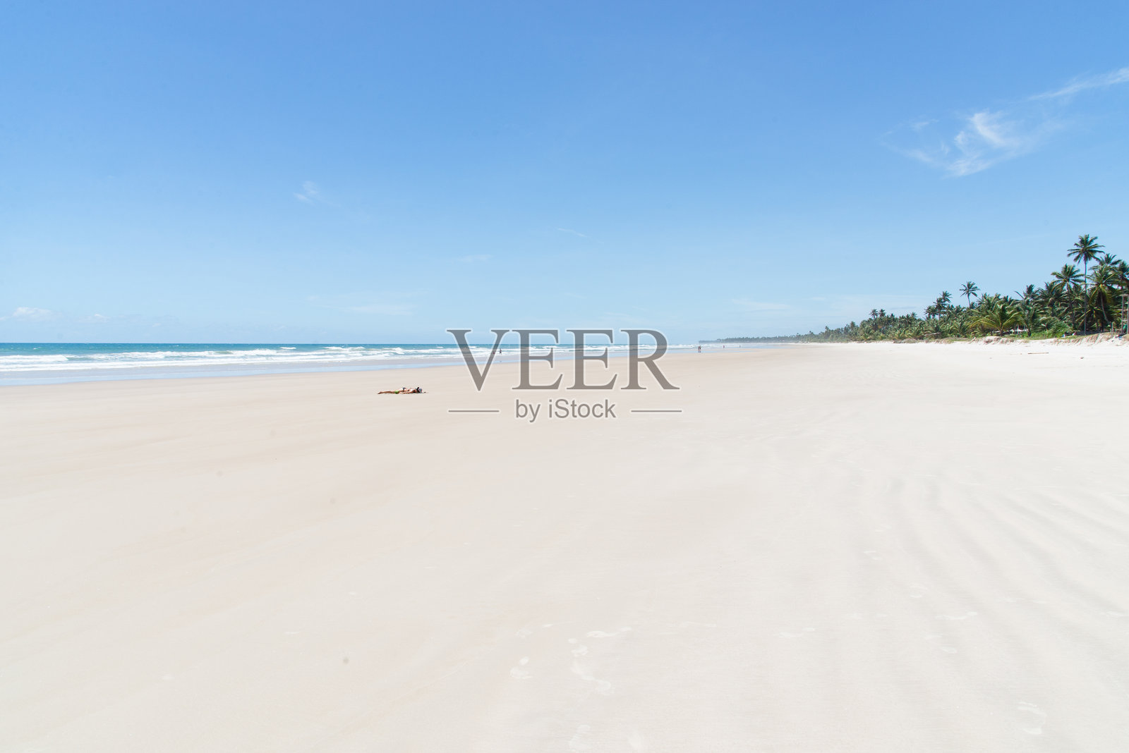 一名游客在巴伊亚州伊塔卡雷市的沙滩上享受强烈阳光的乐趣。照片摄影图片