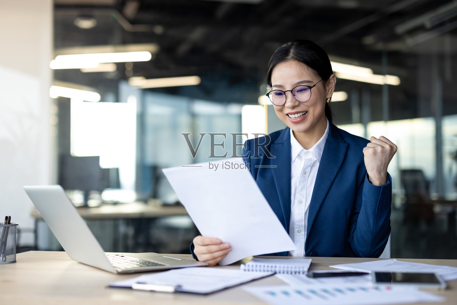 在现代办公室里庆祝成功的亚洲女商人照片摄影图片