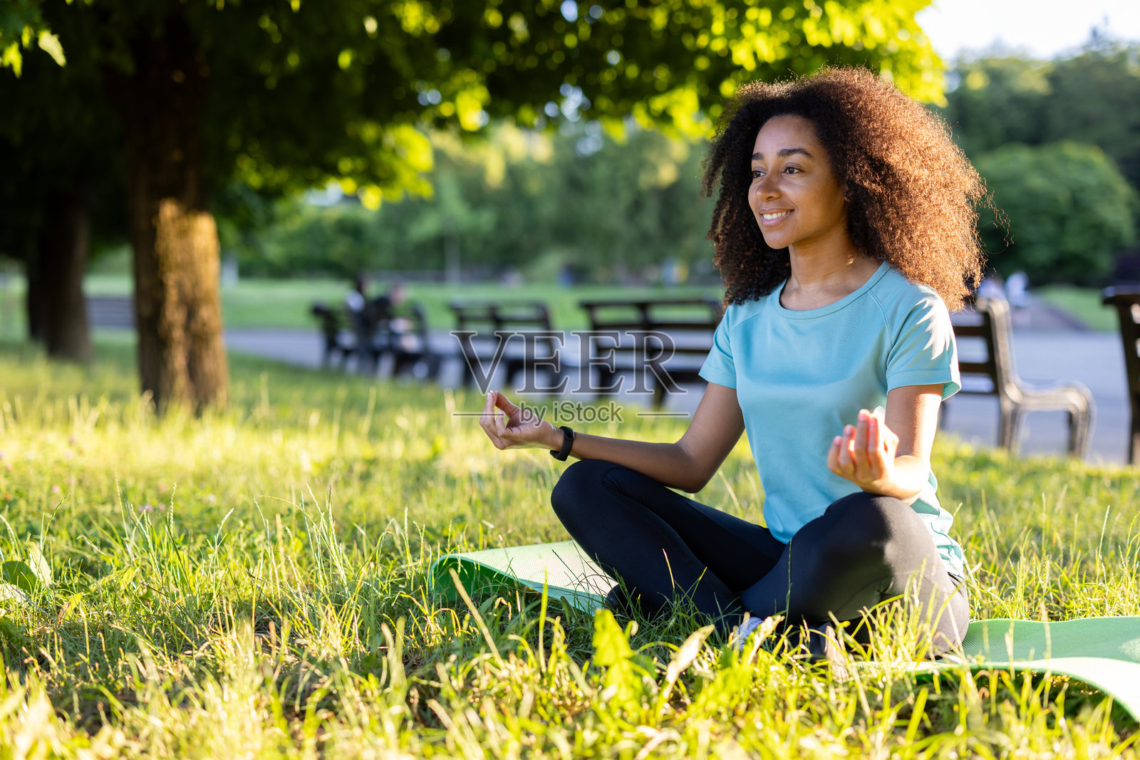在阳光明媚的公园里户外冥想的女人：练习正念，在自然中放松照片摄影图片