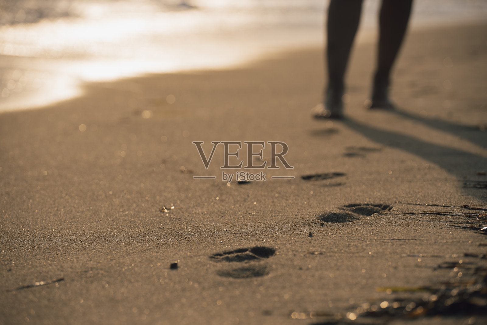 女性的腿在海滩上走过海水和沙滩照片摄影图片