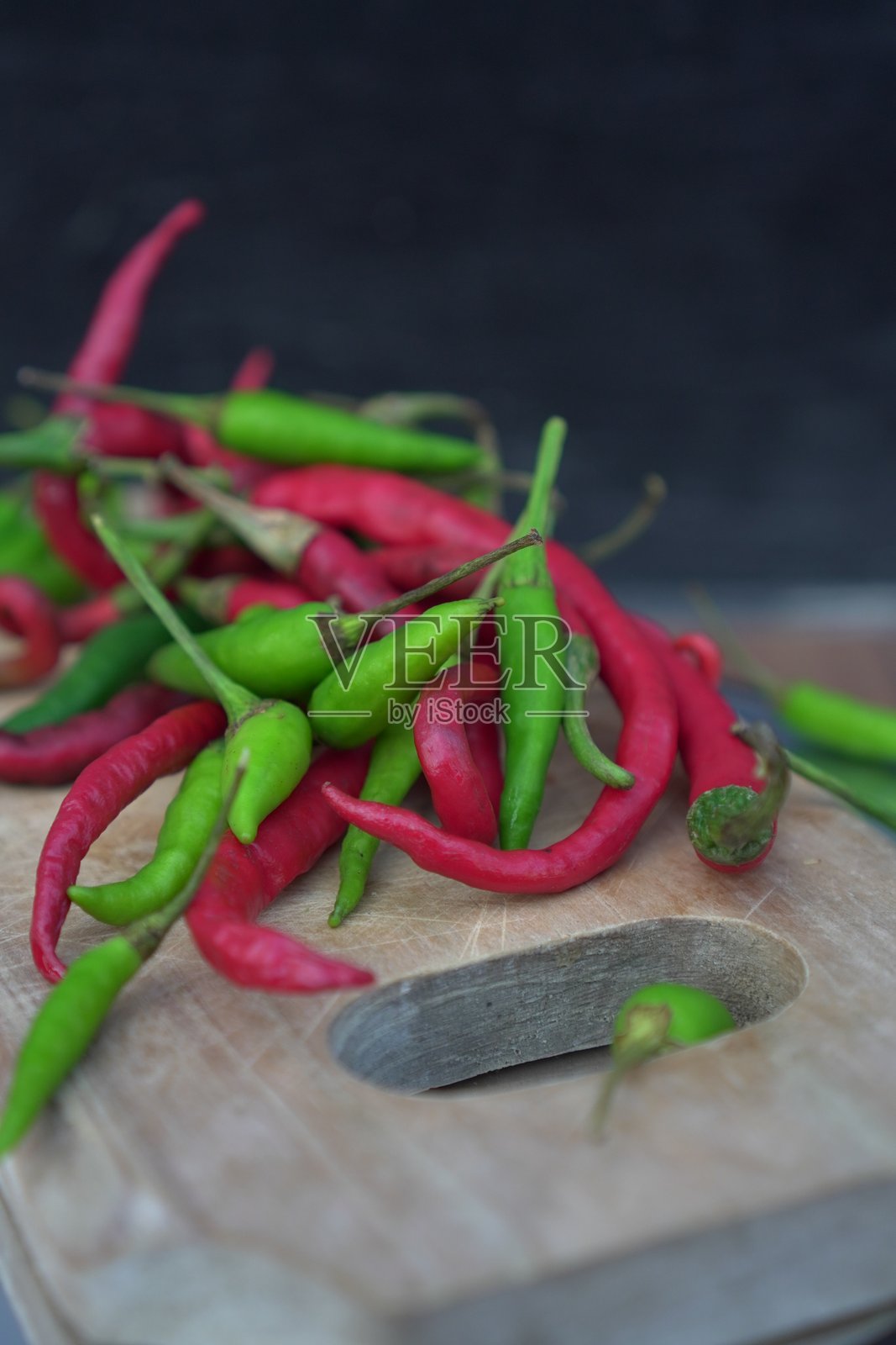 红色和绿色辣椒放在木砧板上照片摄影图片