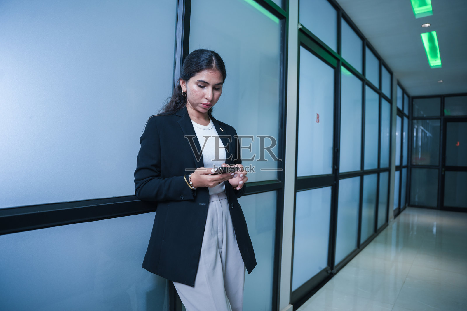 年轻印度女商人在办公室走廊打电话照片摄影图片