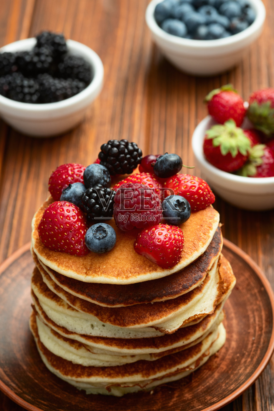 自制美式煎饼叠放在一起，上面放有浆果。俯视图。照片摄影图片