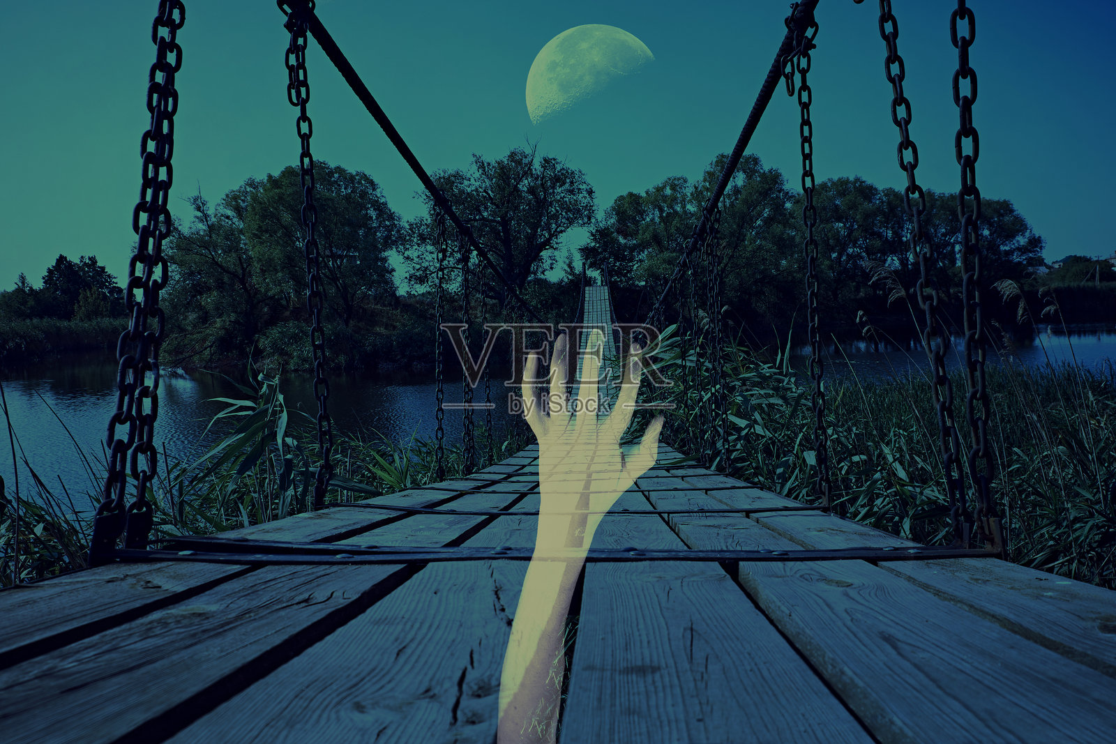 月光下，幽灵般的手伸向一座怪异的悬索桥照片摄影图片