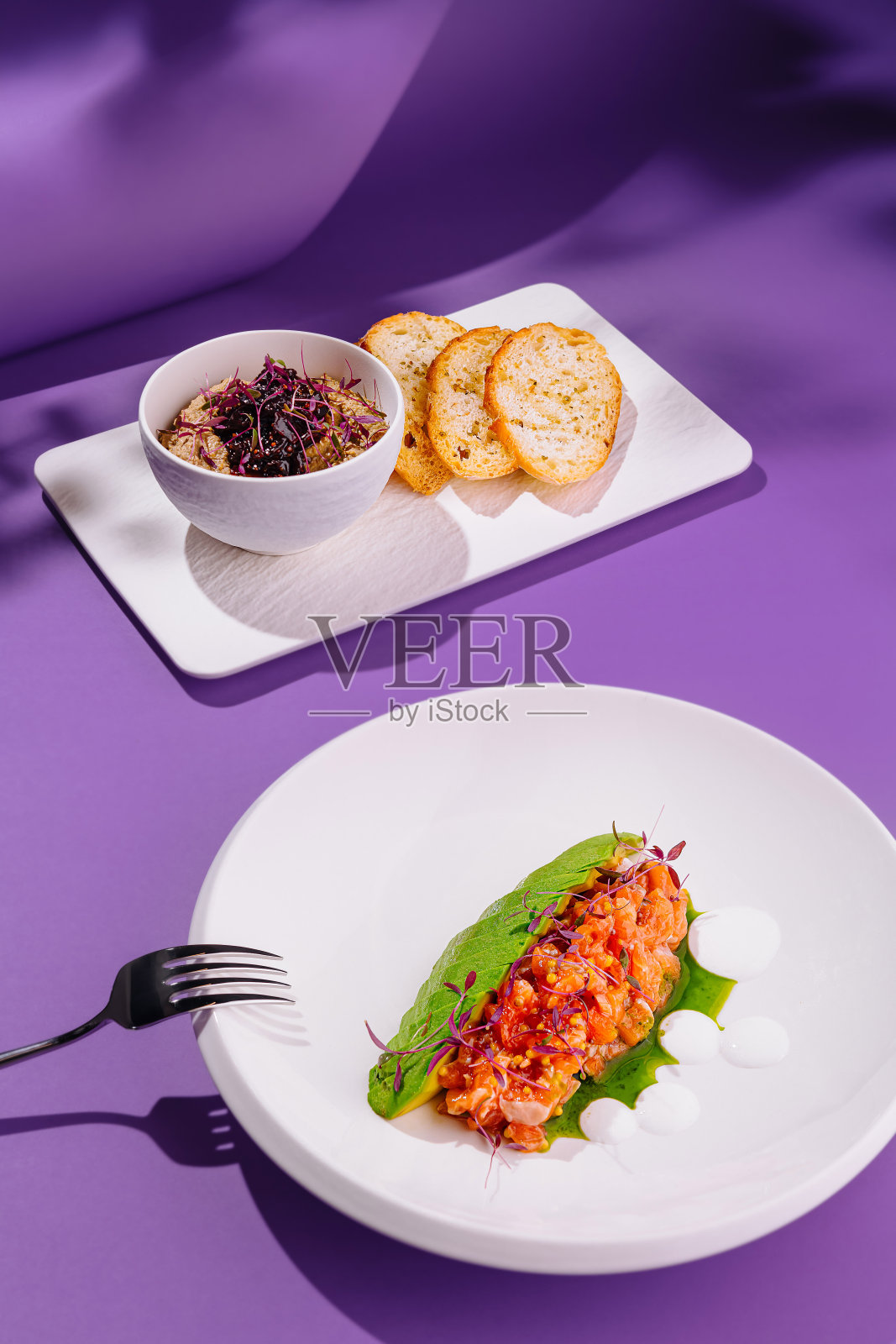 紫色背景上的三文鱼塔塔和吐司的美食佳肴照片摄影图片