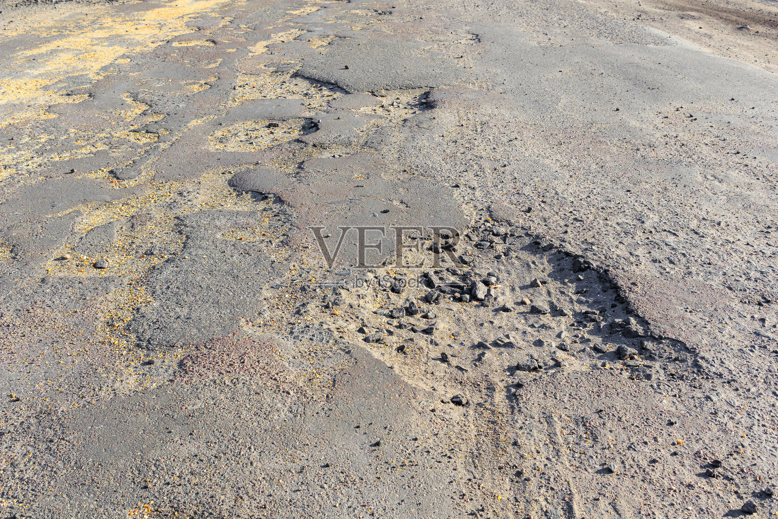 破损路面，布满坑洼和孔洞的沥青路，道路状况不佳，需要维修照片摄影图片