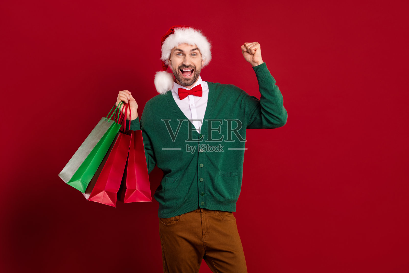 圣诞节男人穿着开衫庆祝冬季促销，红色背景照片摄影图片