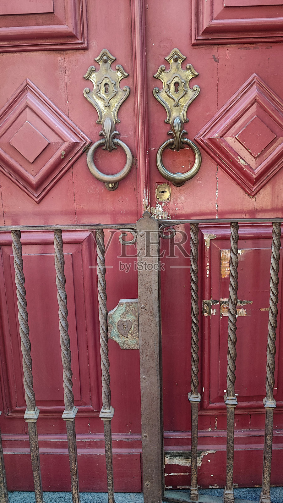 勃艮第酒红色老木门上的复古金属门把手特写照片摄影图片