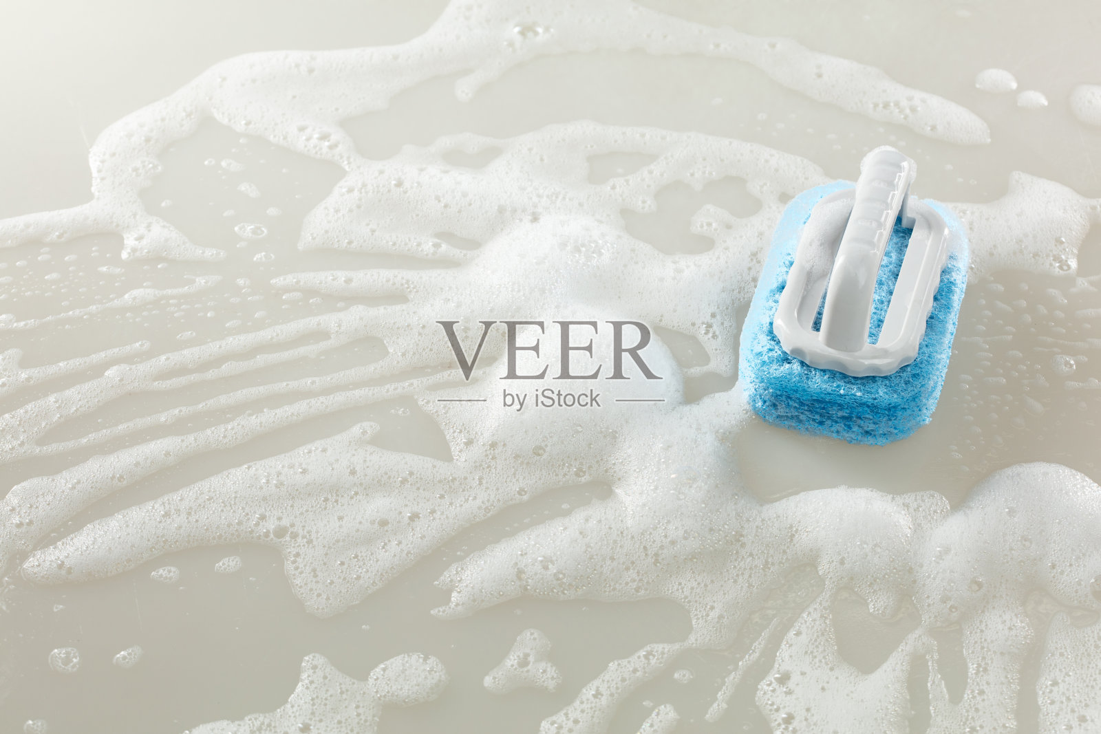 刷子海绵清洁工具在地板上擦拭肥皂泡沫，泡沫四溅，留有空白空间。照片摄影图片