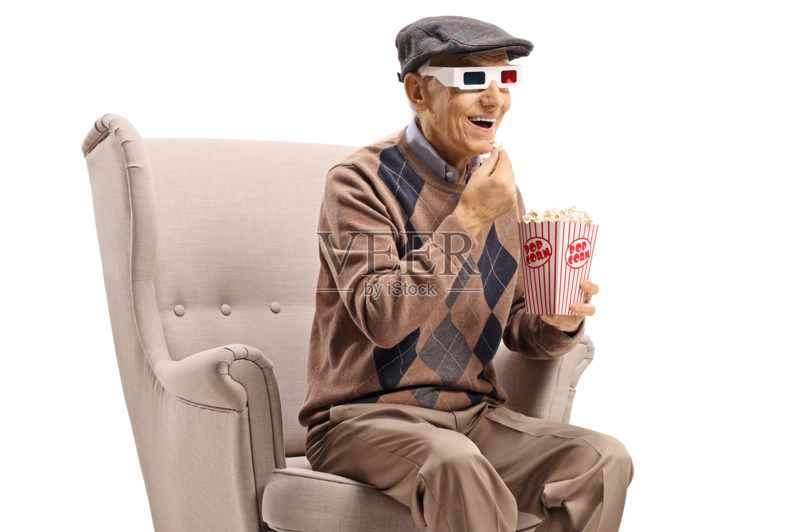 戴着3D眼镜的老人坐在扶手椅上吃爆米花照片摄影图片