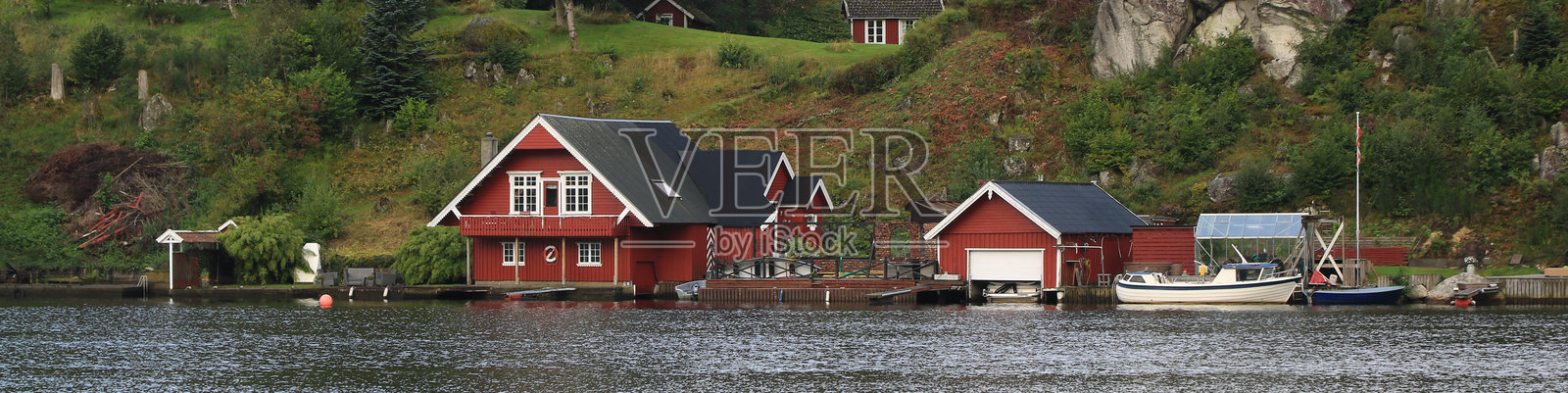 挪威埃格松德的滕斯河岸边美丽的红色船屋和小屋。照片摄影图片