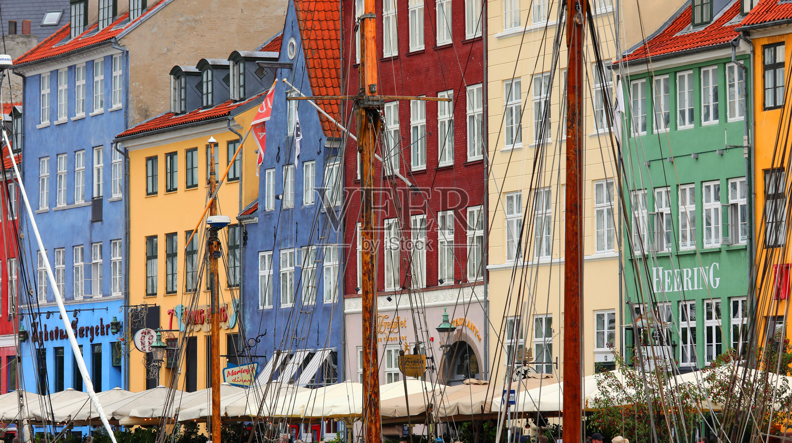 位于名为NYHAVN（新港）的区域的房屋，周围有许多酒吧和餐厅。照片摄影图片