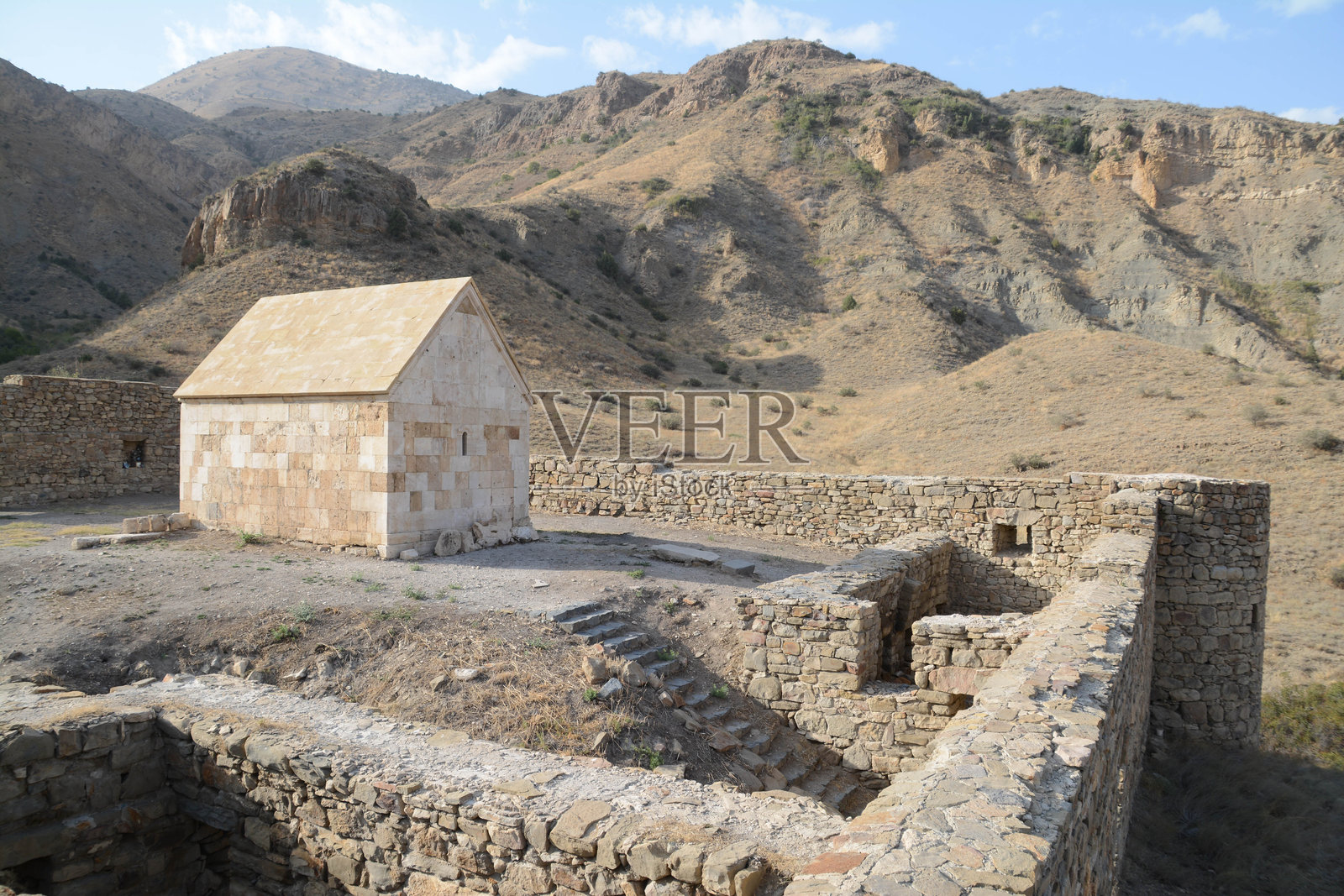 废弃的城堡。城堡内的小庙。位于自然环境中的城堡，坐落在山间。堡垒和教堂。照片摄影图片