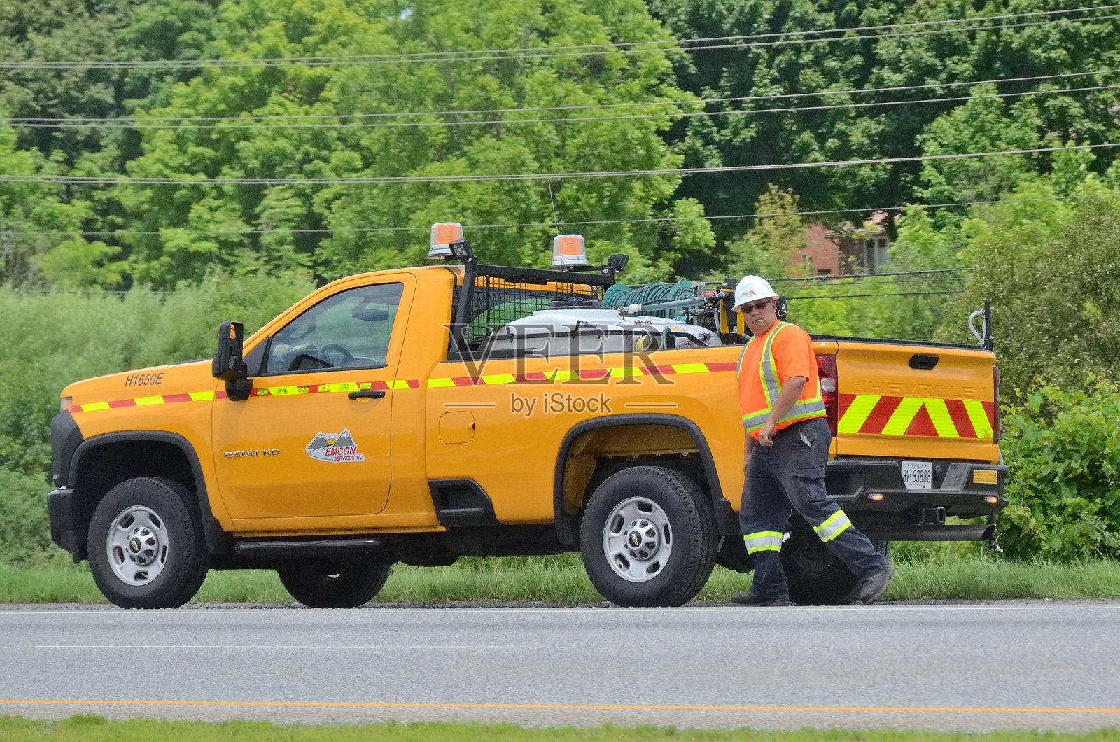 Emcon Services车辆在圭尔夫的汉伦高速公路肩部停靠，负责根据交通部（MTO）合同进行高速公路维护。照片摄影图片