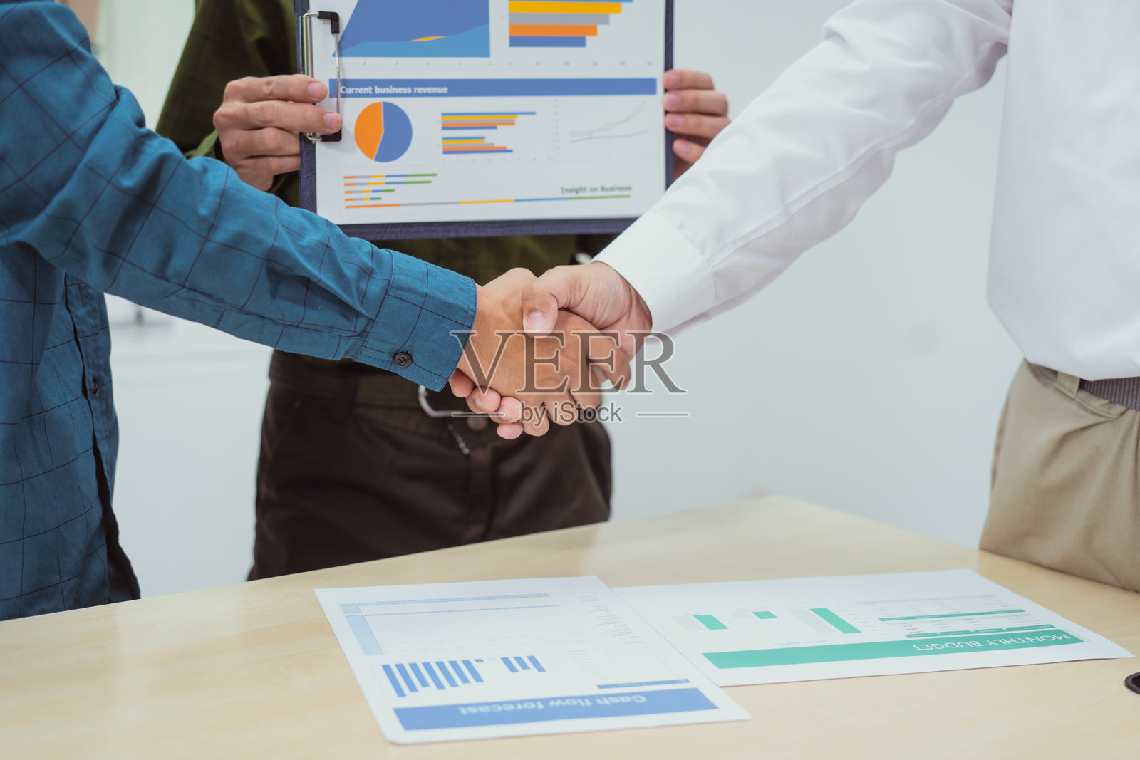 办公室会议期间商务人士握手的特写，讨论围绕数字营销管理、财务分析、商业写作、教学、风险投资照片摄影图片