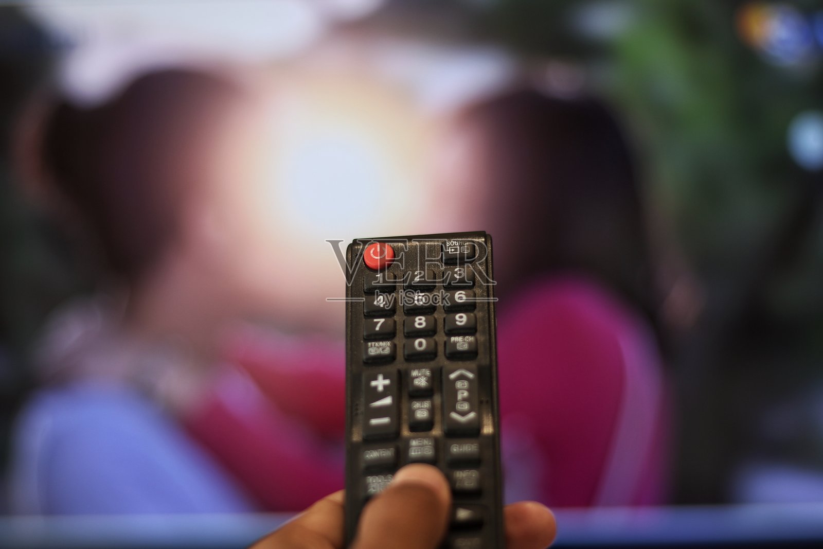 电视娱乐概念：手紧握电视遥控器照片摄影图片