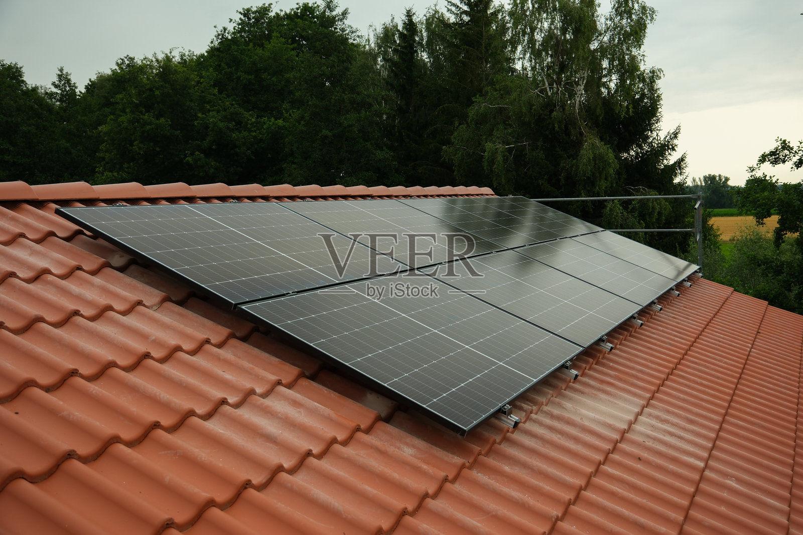 红色瓦片屋顶上的黑色太阳能电池板照片摄影图片