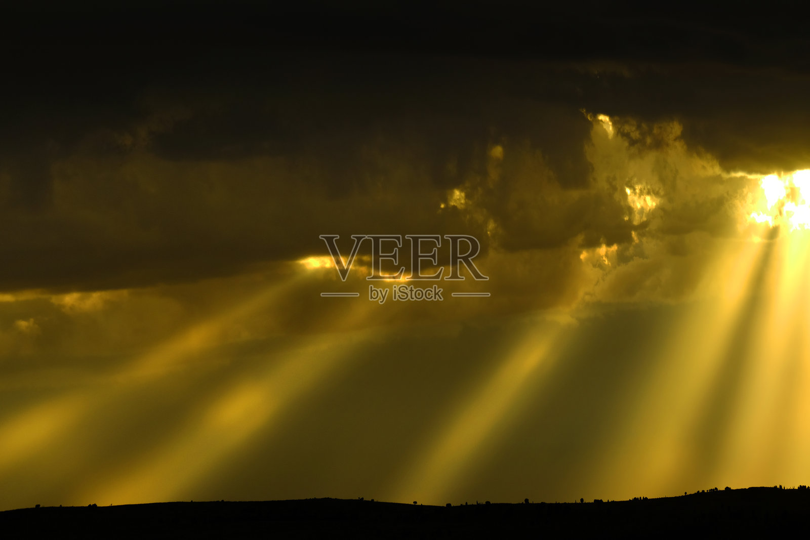 暴风雨天空中洒下的金色温暖阳光照片摄影图片