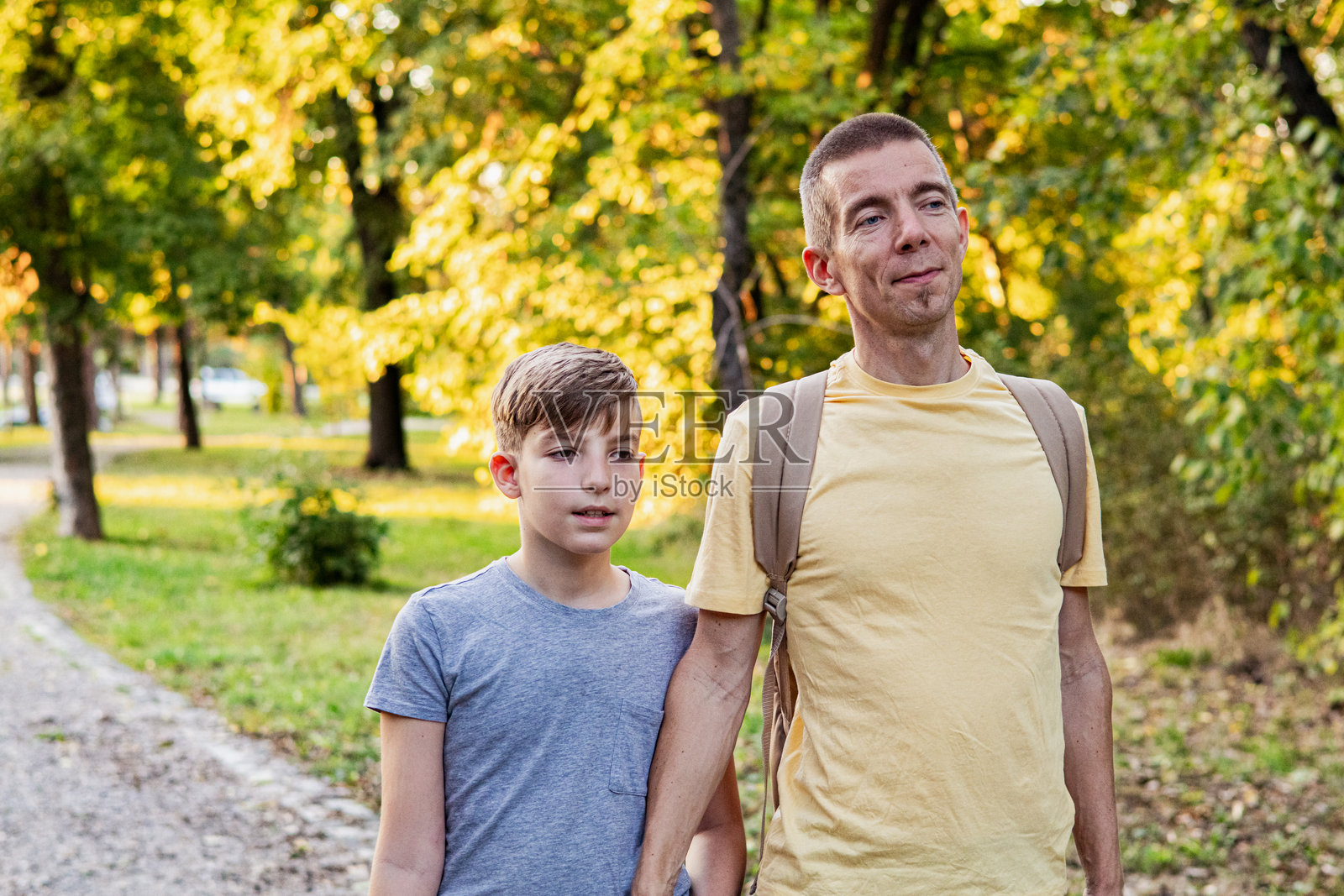与自然亲密接触。父亲和儿子在秋天的森林中探索并学习植物。照片摄影图片