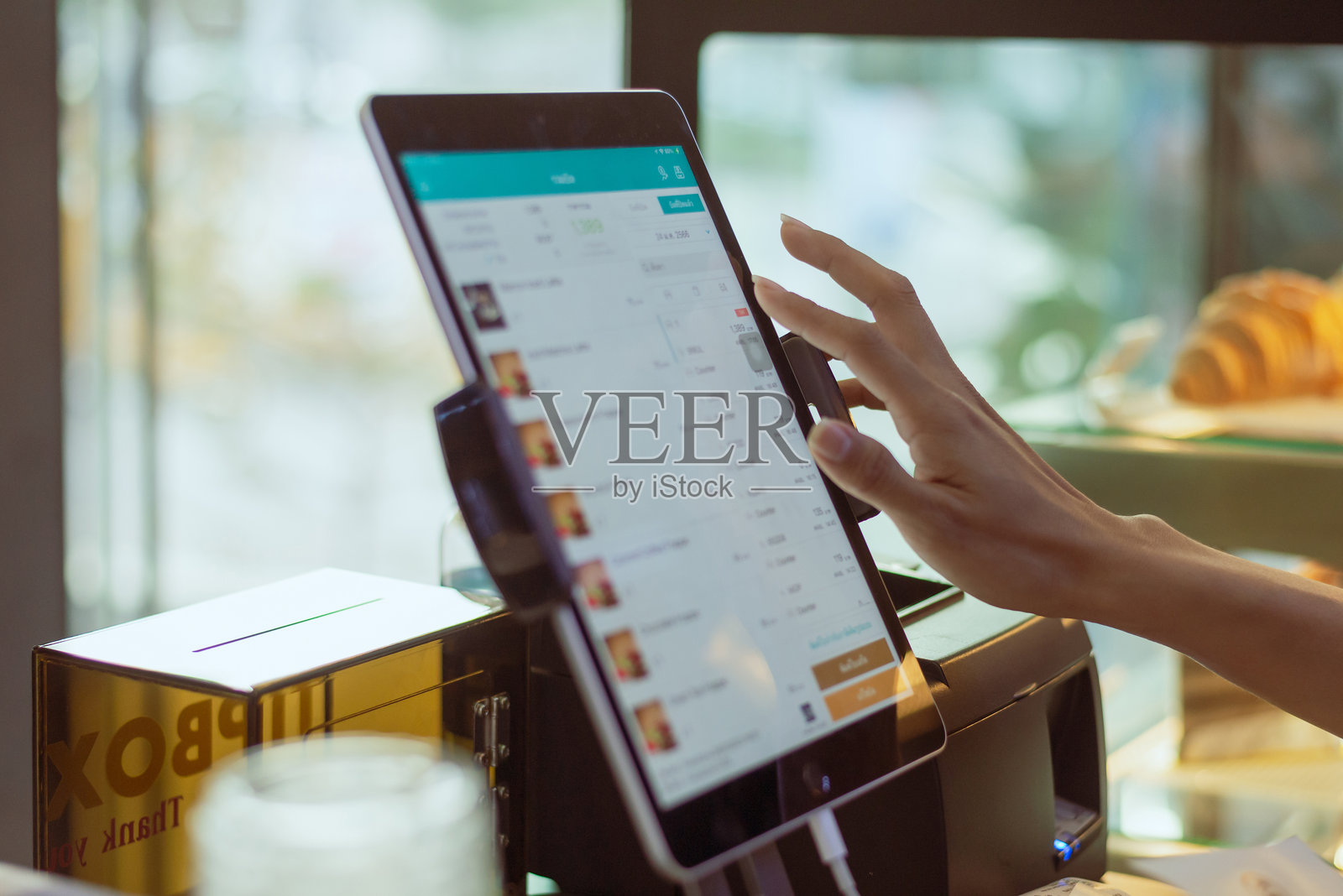 餐厅员工在检查电脑上的菜单账单，体现无现金支付技术和资金转移概念。照片摄影图片