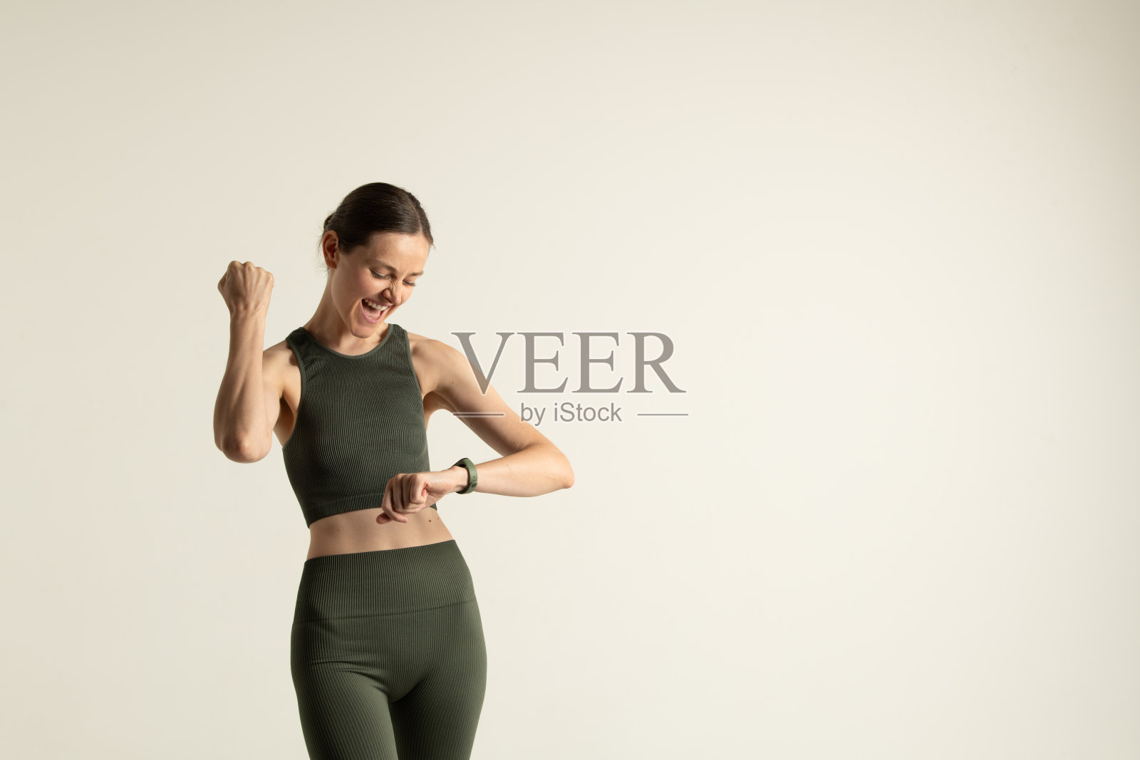 一位快乐的年轻女性正在查看她手腕上的健身追踪器。照片摄影图片