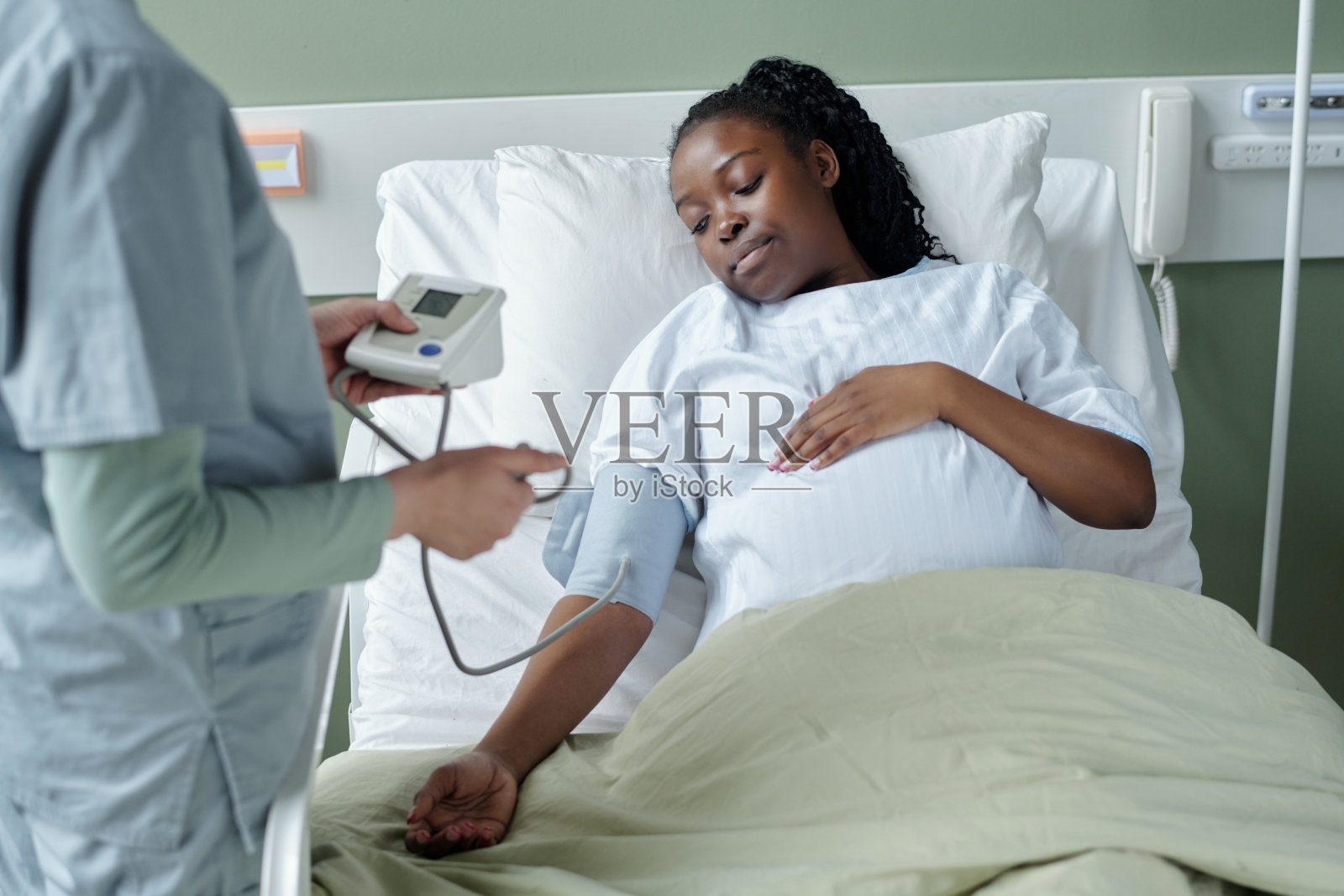 在医院病床上为孕妇量血压照片摄影图片