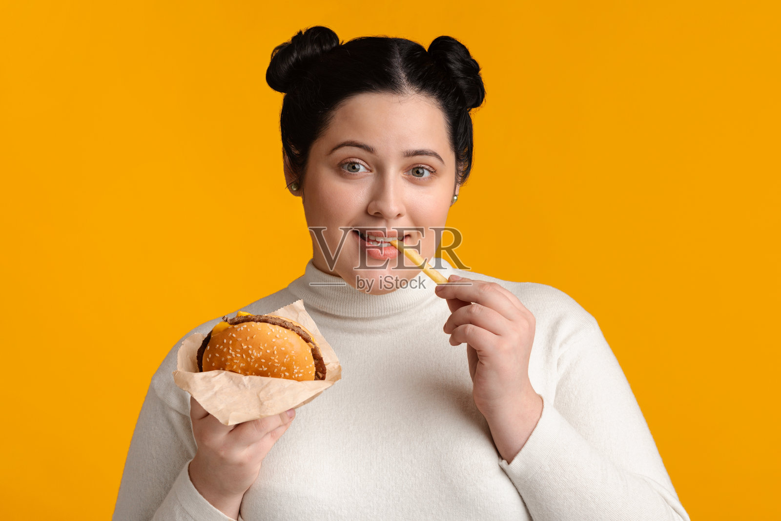 享受快餐，吃汉堡和炸薯条的年轻超重女人照片摄影图片