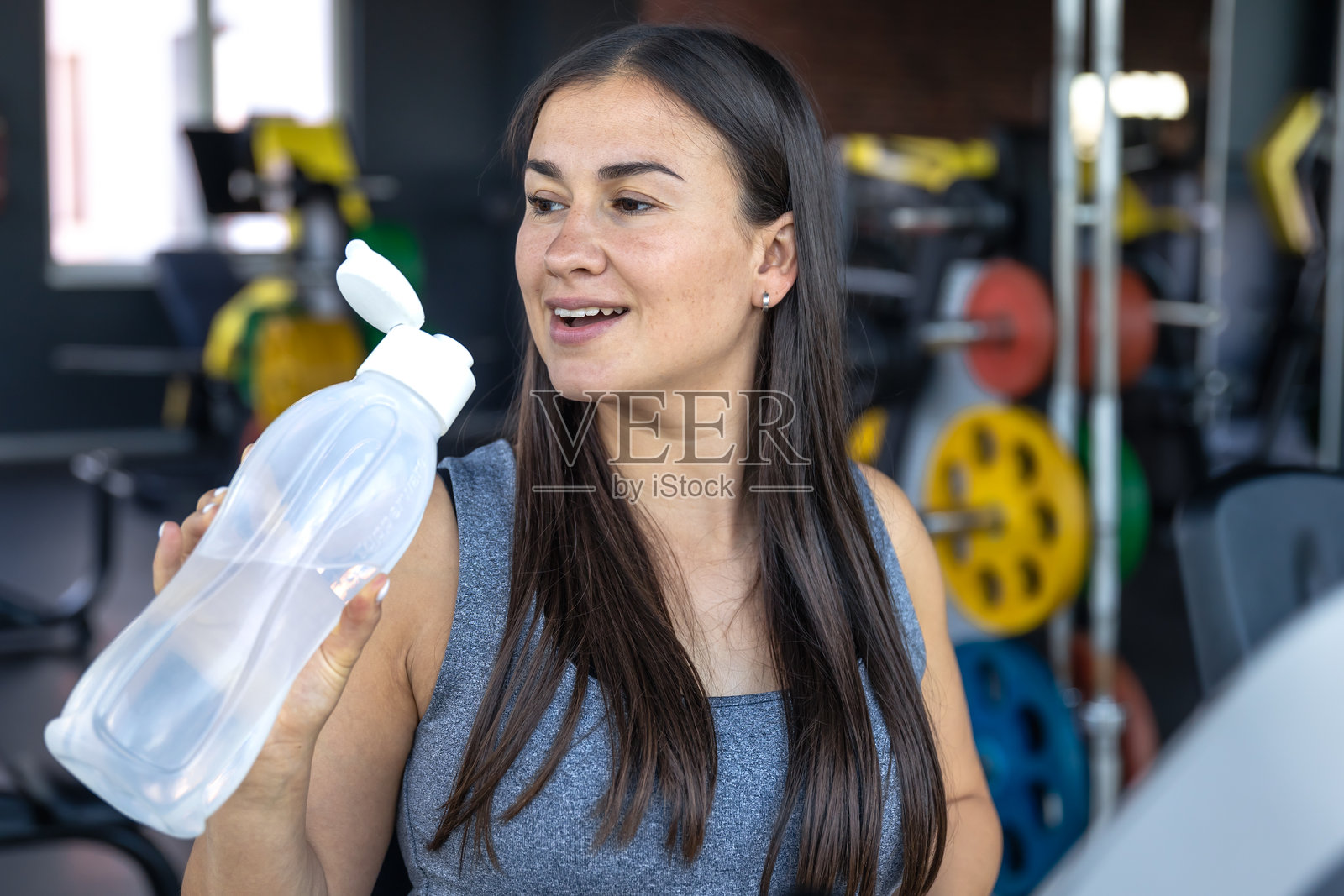 健身房里的孕妇与水。运动与健康生活方式。照片摄影图片