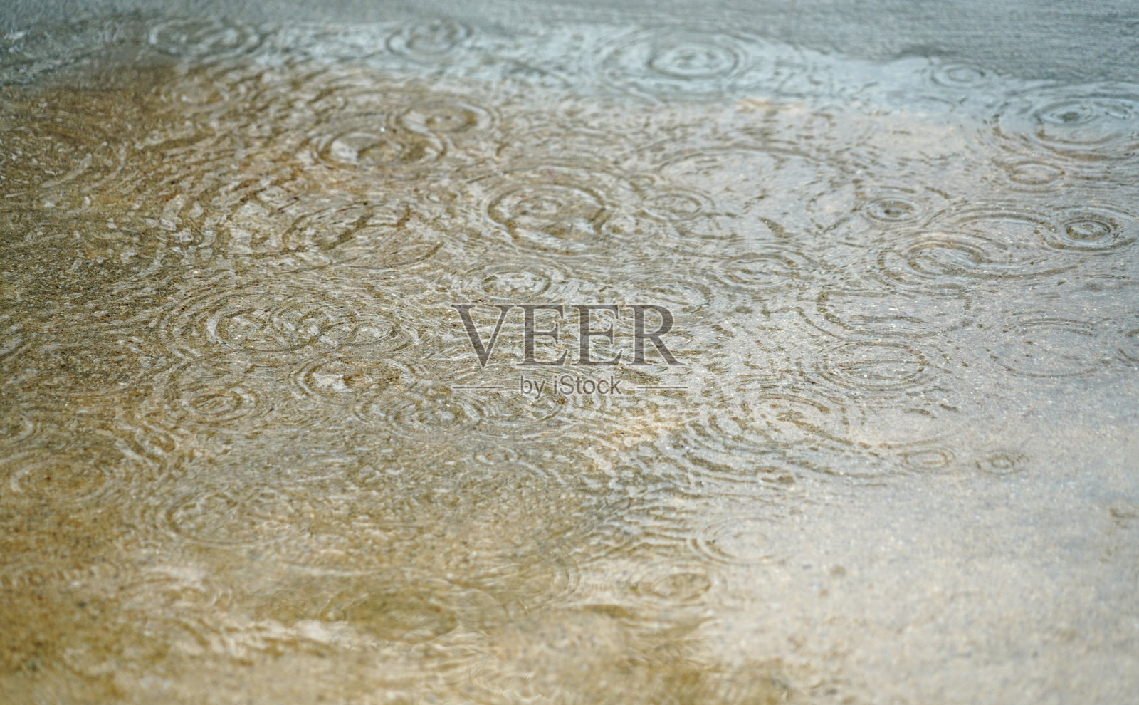 雨滴在水洼中溅起涟漪的特写镜头照片摄影图片