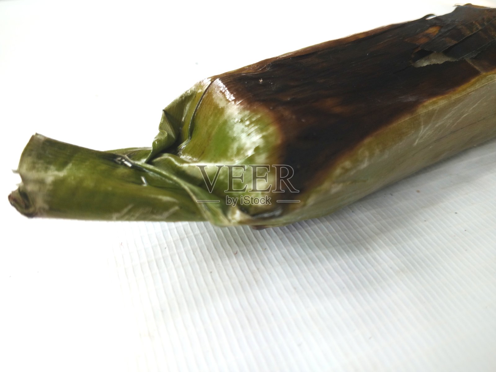 巴卡尔米饭，香蕉叶包裹的白色粘米饭，经过烤制，背景为白色。照片摄影图片