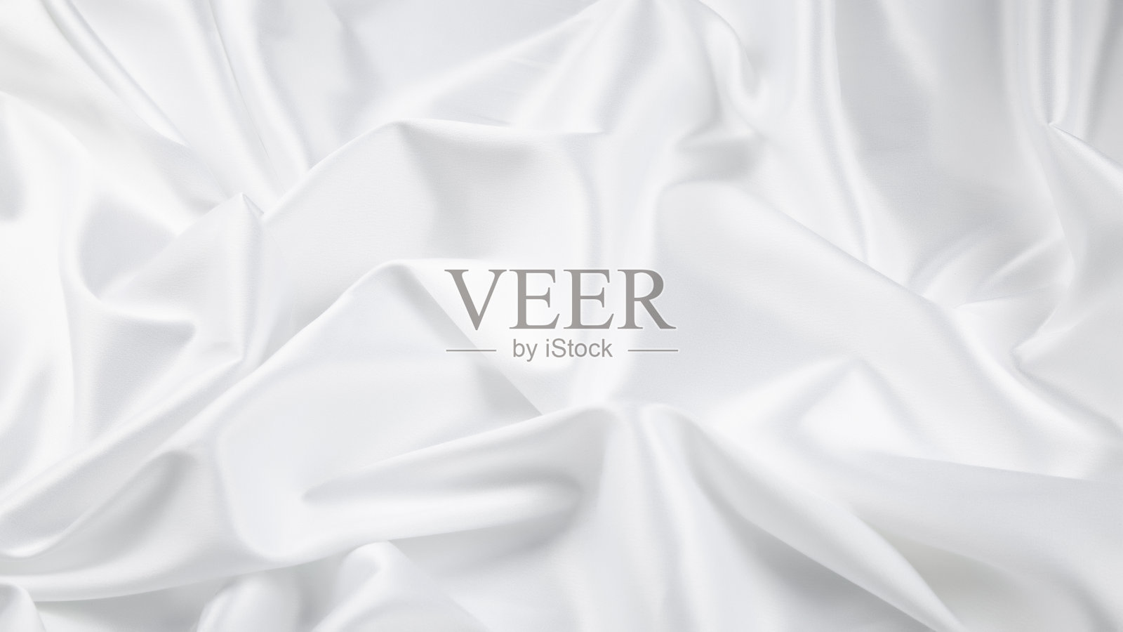 白色缎面丝滑布料。带有褶皱波浪的织物垂坠，柔和的波浪。奢华的背景设计。照片摄影图片