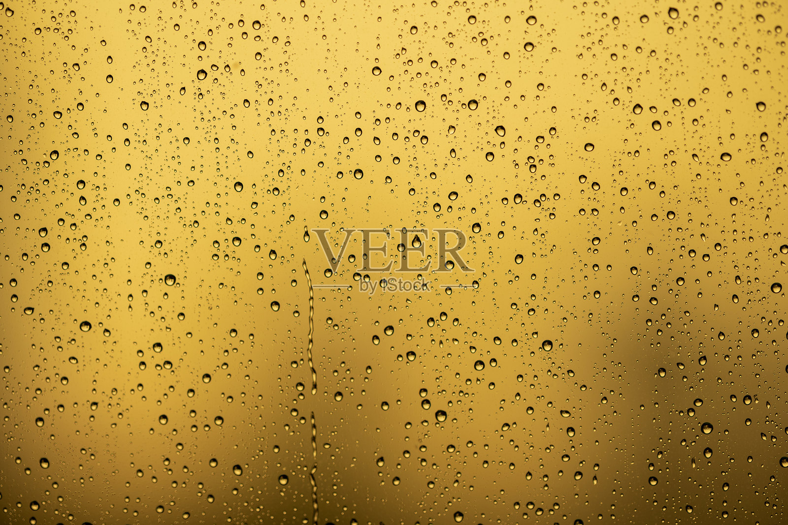 窗户上的雨滴和金色背景的水痕照片摄影图片